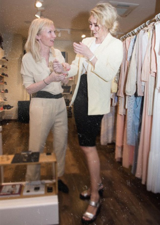 Stylistin julia weller stylt ein Model in einem Showroom von vagabond shoes. Die Fashion stylistin trägt einen Overall .Das Modell steht vor einer Kleiderstange. Es weden outfits gestyled kombiniert mit ecco Schuhen z.B. silberne Sandalen. Es geht um das persönliche Styling einer Person.